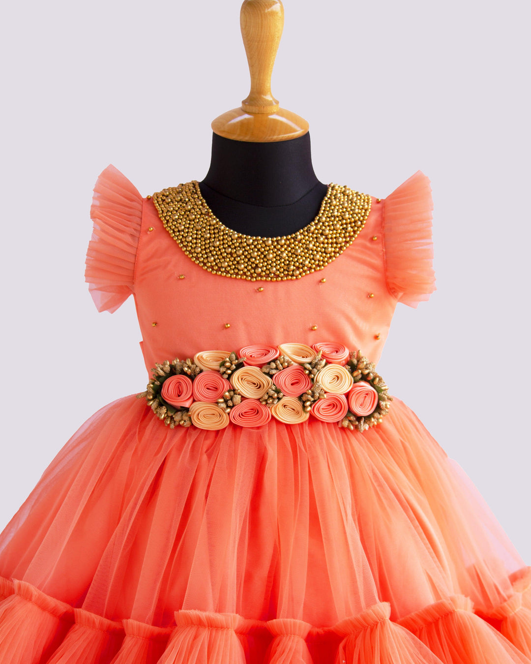 Coral Peach Shade Handwork Flower Frock
Material: Coral peach shade handwork flower frock is made with soft nylon net fabric. The yoke portion of the frock is designed with handwork design. Golden colour