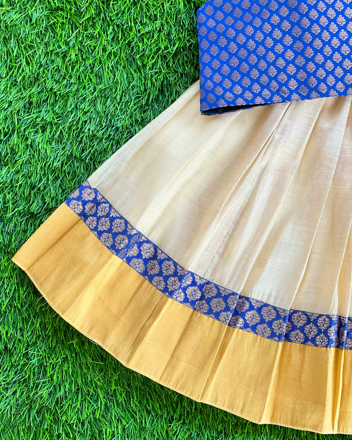Baby girl in cream and royal blue Kerala Kasavu lehenga birthday dress