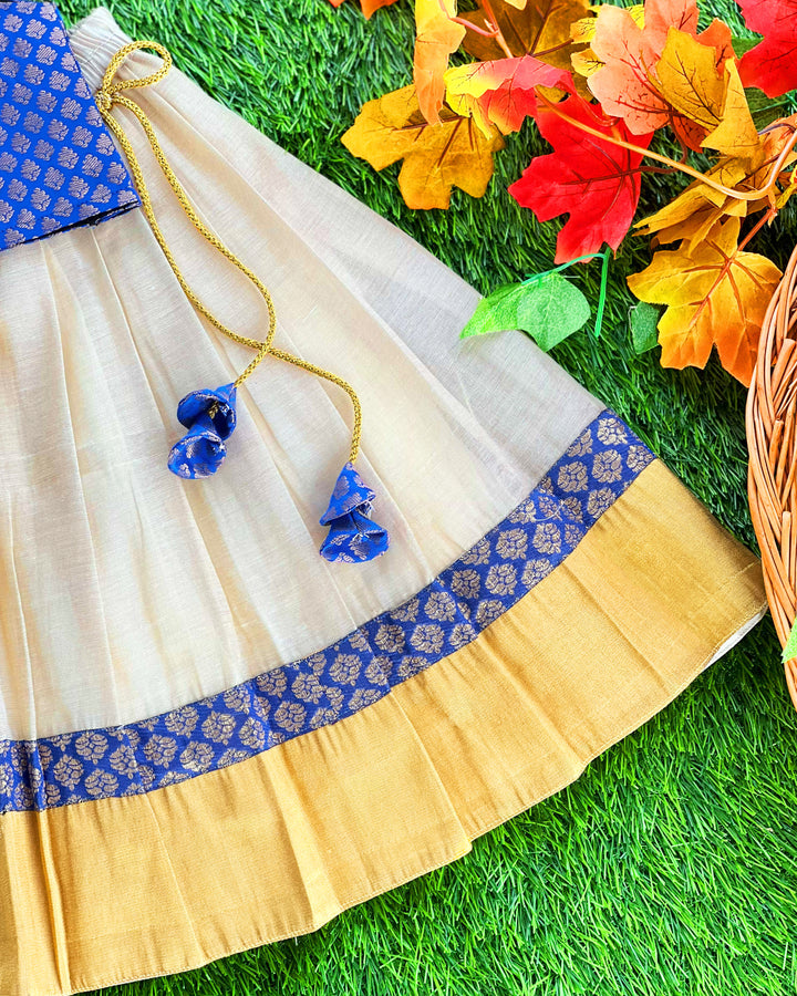 Baby girl in cream and royal blue Kerala Kasavu lehenga birthday dress