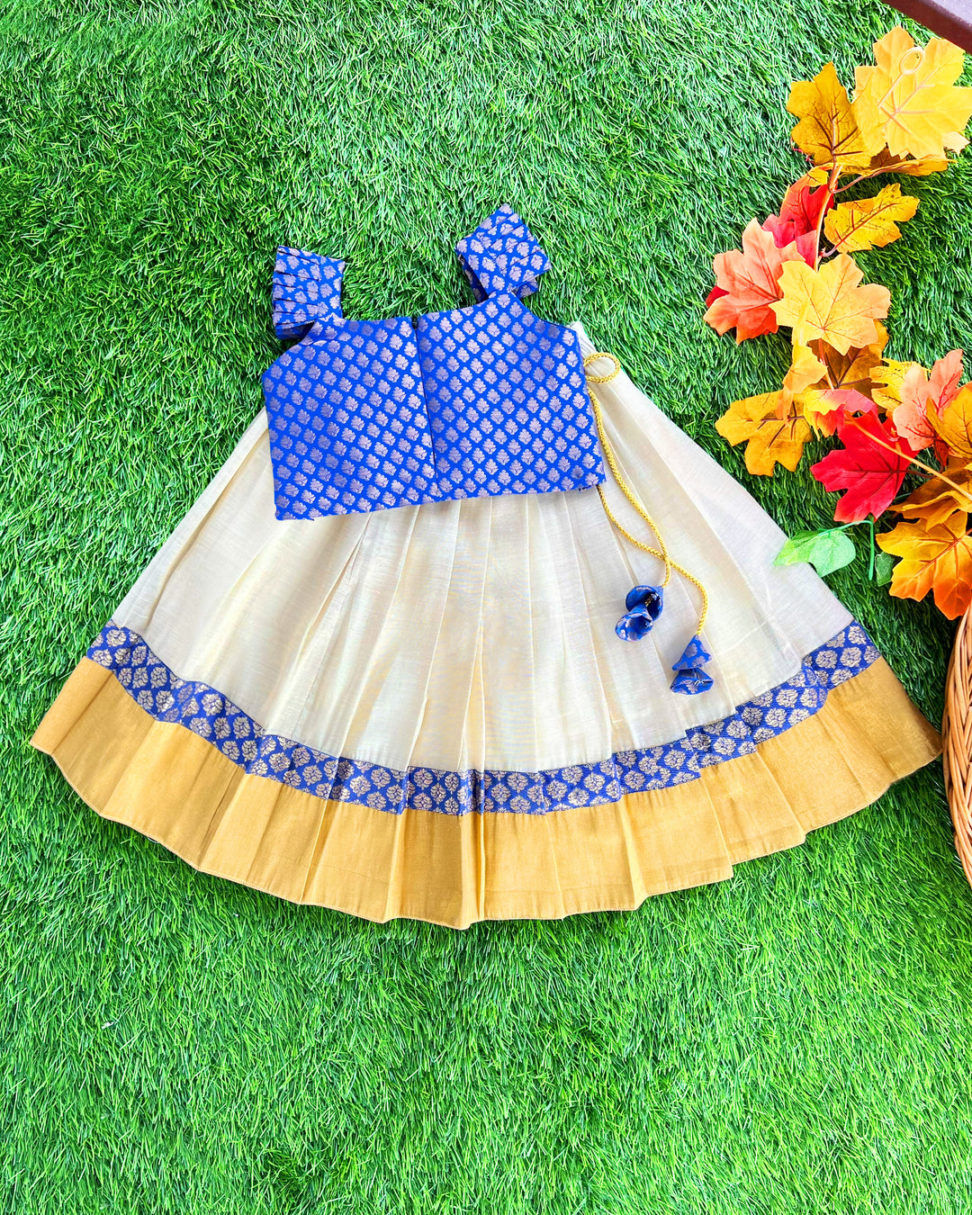 Baby girl in cream and royal blue Kerala Kasavu lehenga birthday dress