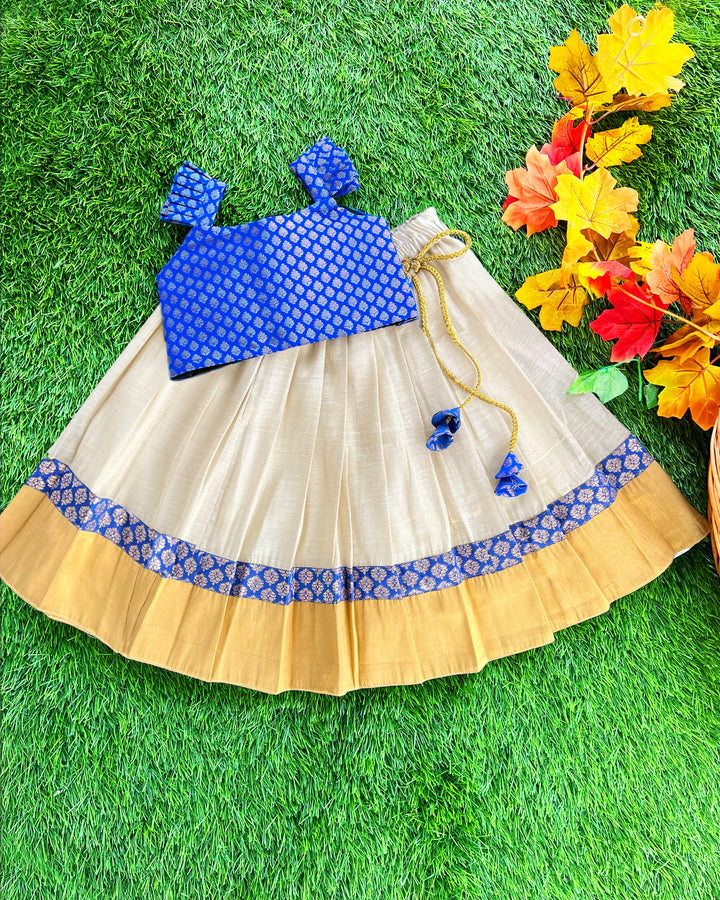 Baby girl in cream and royal blue Kerala Kasavu lehenga birthday dress