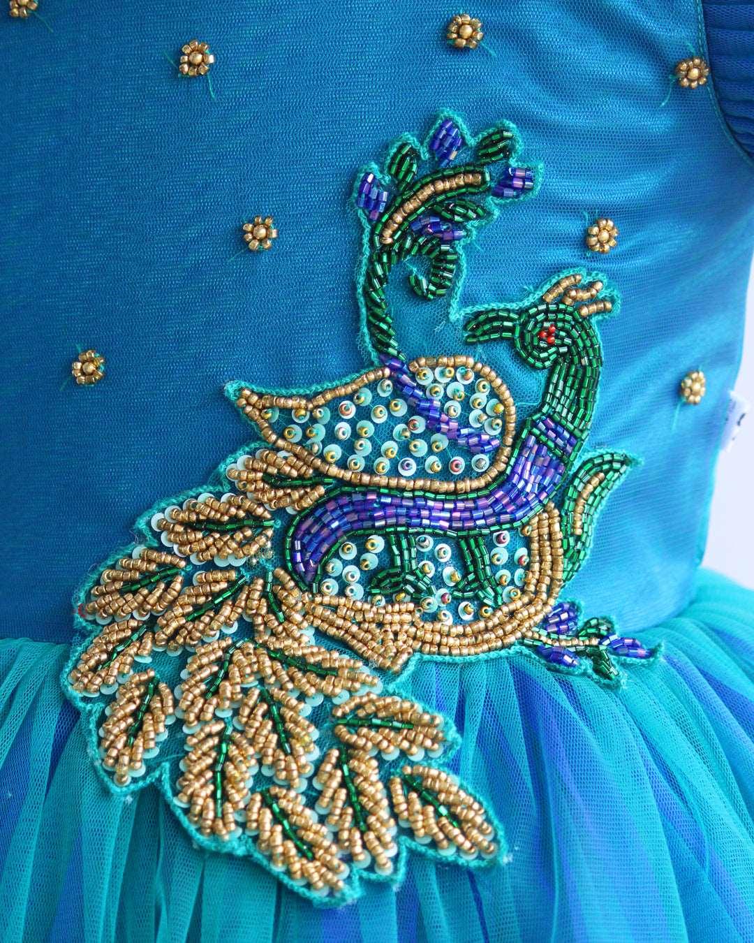 Peacock theme Applique Party wear Frock.
Material: Royal blue and Tourqise green colour net is using in the main portion of the dress. Royal blue colour net is pleating in the bottom portion. Over all colo