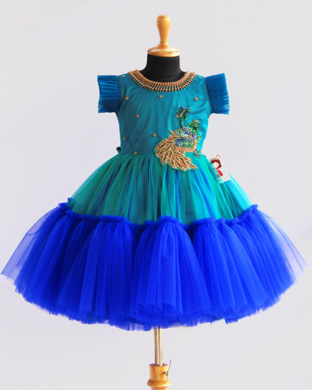 Peacock theme Applique Party wear Frock.
Material: Royal blue and Tourqise green colour net is using in the main portion of the dress. Royal blue colour net is pleating in the bottom portion. Over all colo