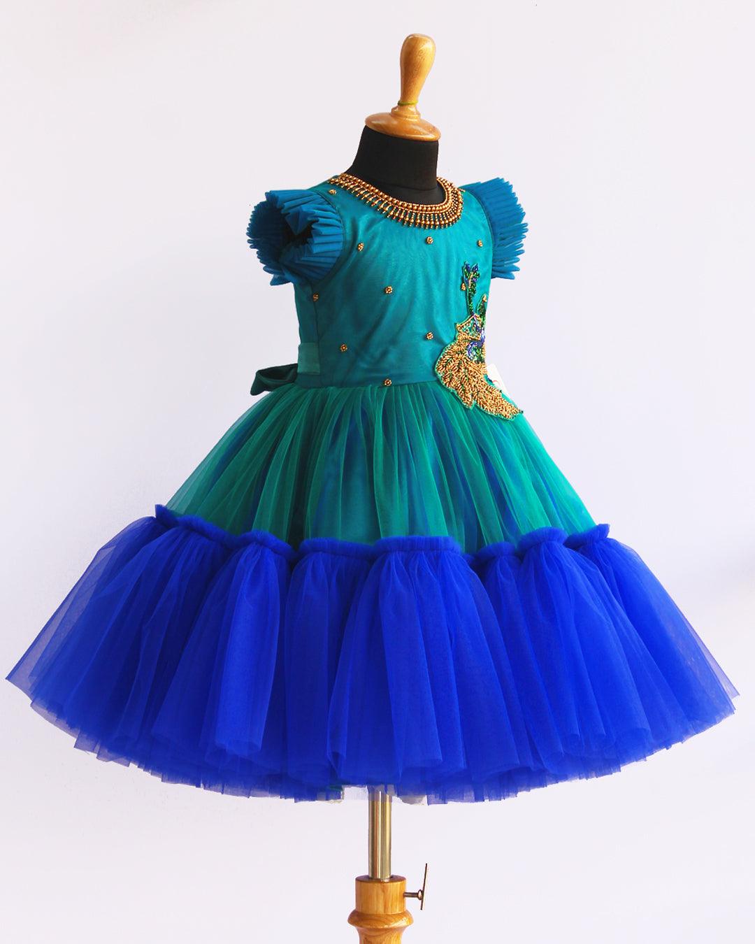 Peacock theme Applique Party wear Frock.
Material: Royal blue and Tourqise green colour net is using in the main portion of the dress. Royal blue colour net is pleating in the bottom portion. Over all colo