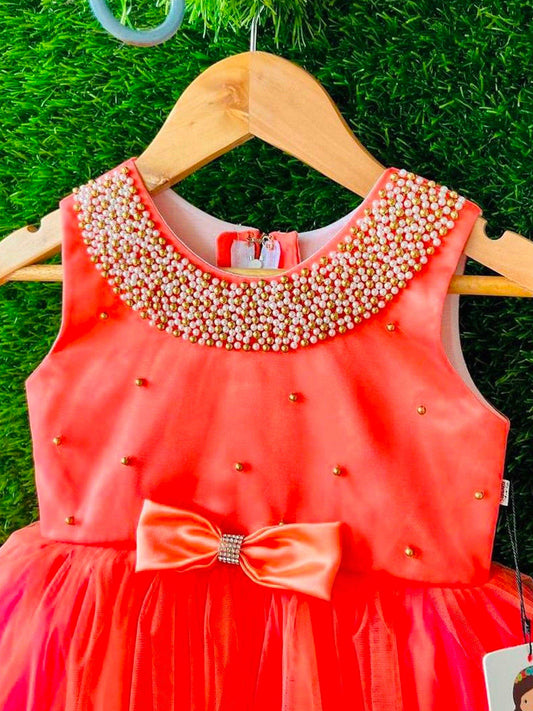 Tomato Coral Beaded Neck Knee-length Frock
Material: Tomato Coral Shade Frock mono net in the end portion. Yoke portion is designed with handwork pattern with neck fully designed with beads.  Center portion 