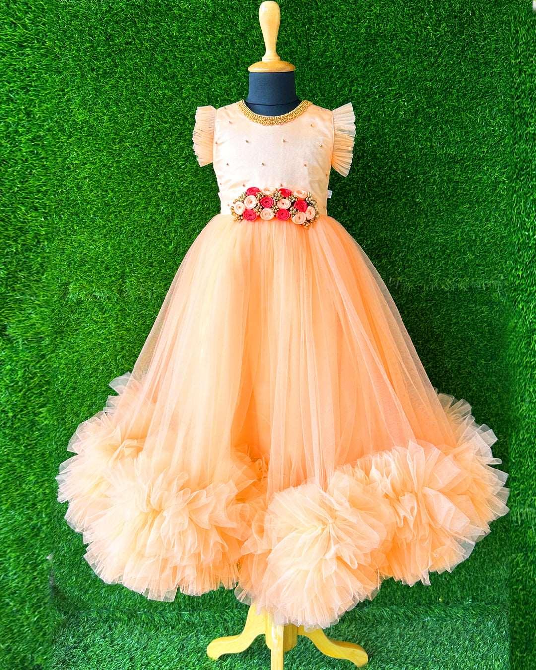 Light Peach Hand Embroidery Flower Gown- Matching Hair Band.
Material : Light Peach Colour long Gown. Light peach colour net is the main material of the gown.Golden beaded hand work is done on the neck portion and beads sprea