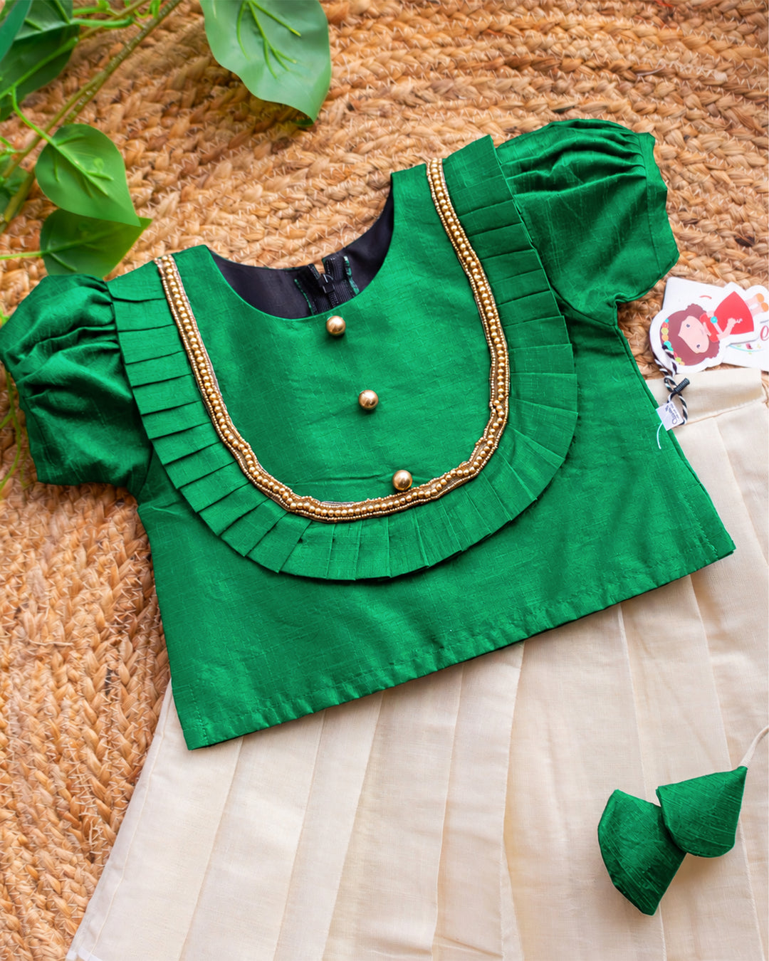 Close-up of the blouse detailing on a cream green Onam special Kerala Kasavu lehenga choli for baby girl.