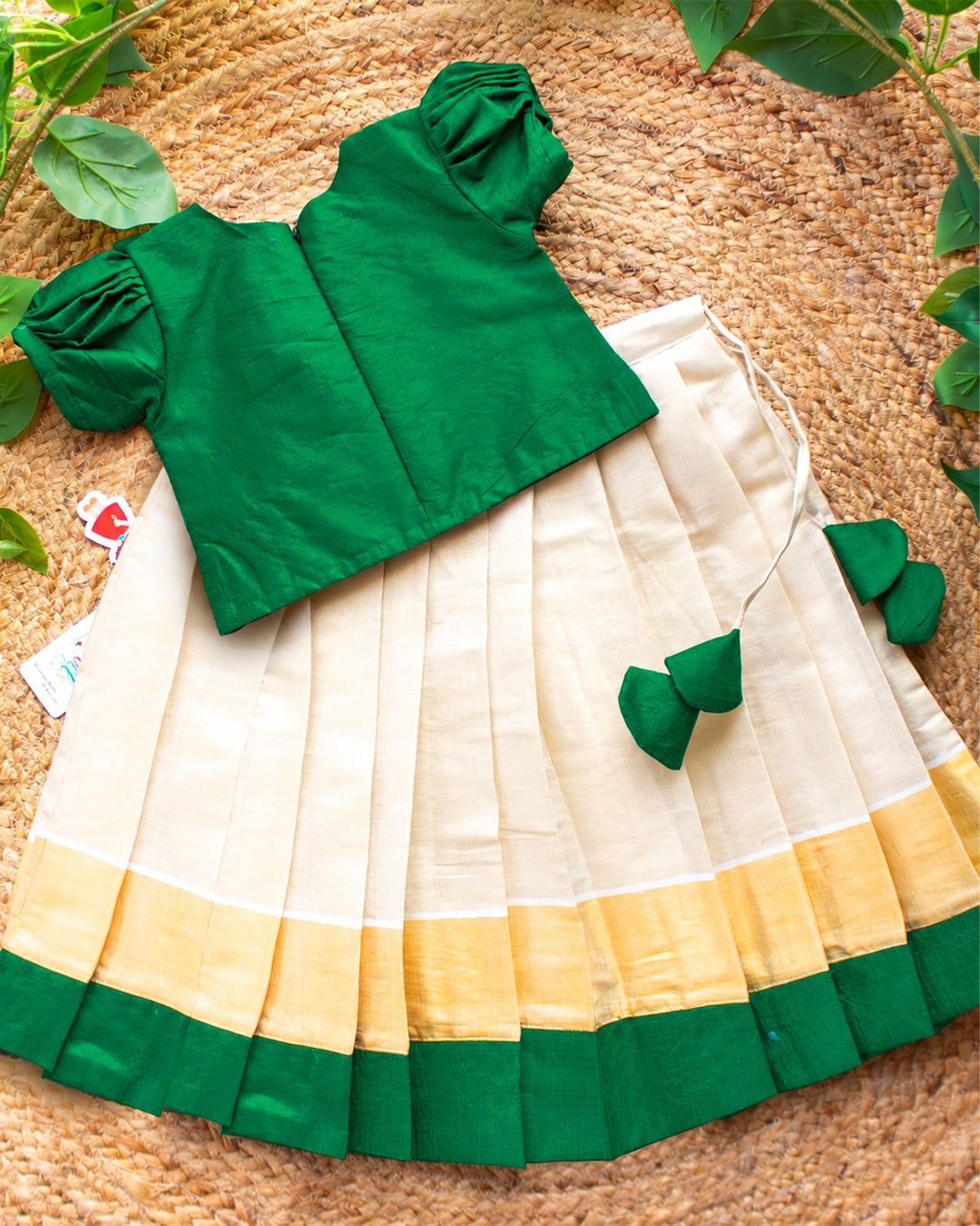 Back view of cream green Kerala Kasavu lehenga choli for baby girl highlighting the blouse design and traditional finishing.