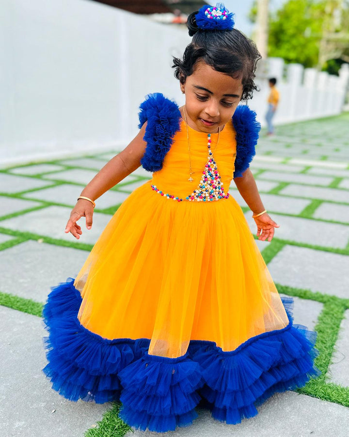 Sun Yellow & Navy blue combo Paris Handwork Birthday Gown
Material: Sun Yellow &amp; Navy blue soft nylon net is used for making this beautiful Gown .Yoke portion of the gown is designed with yellow net with multi colours 