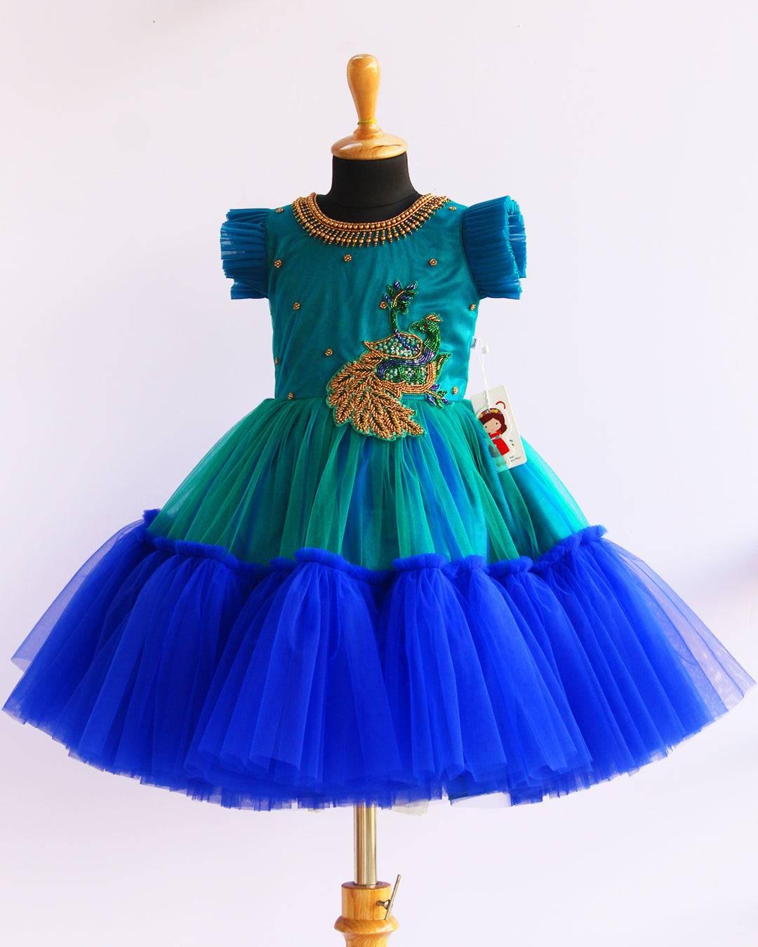 Peacock theme Applique Party wear Frock.
Material: Royal blue and Tourqise green colour net is using in the main portion of the dress. Royal blue colour net is pleating in the bottom portion. Over all colo