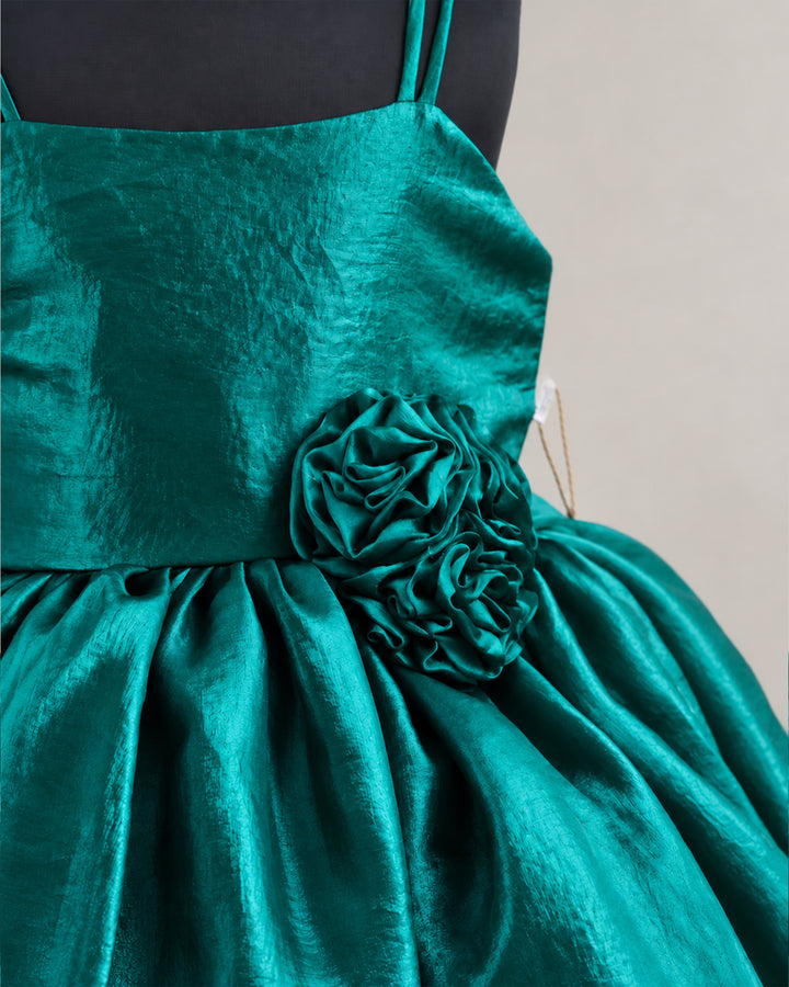 Close-up of the rich peacock green velvet and sheer organza fabric of a baby girl’s premium partywear frock.