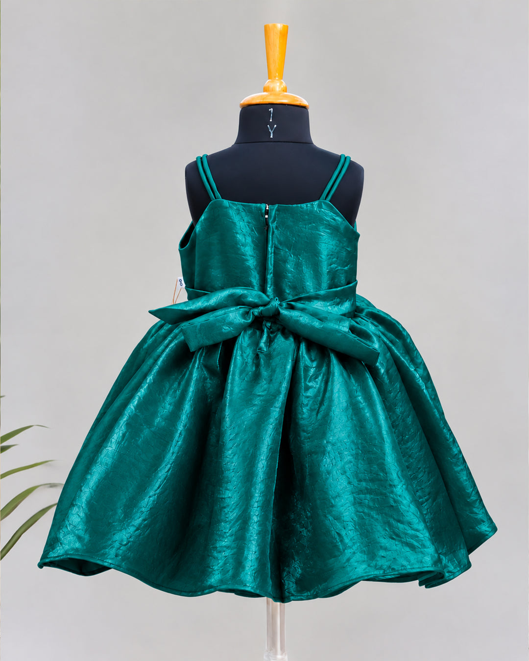 Back view of peacock green velvet organza strap sleeve frock for baby girl highlighting the back design and finishing.