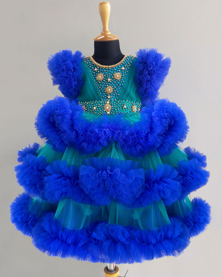 Peacock and royal blue birthday dress for girls with heavy handwork and 3-step ruffles, ideal for parties and special occasions.