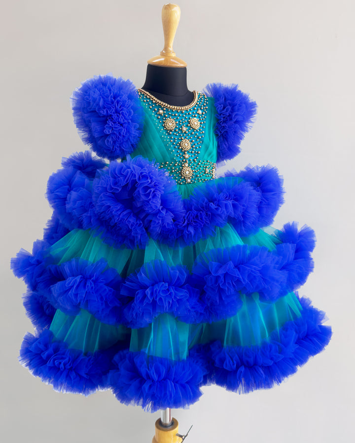 Peacock and royal blue birthday dress for girls with heavy handwork and 3-step ruffles, ideal for parties and special occasions.