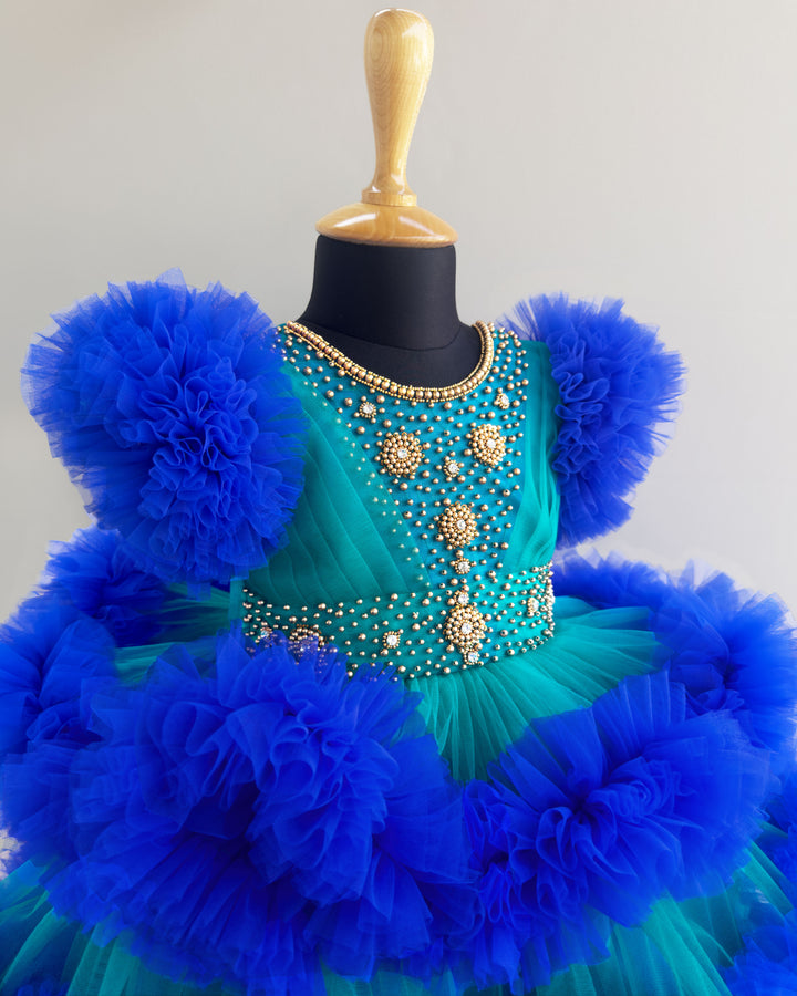 Peacock and royal blue birthday dress for girls with heavy handwork and 3-step ruffles, ideal for parties and special occasions.