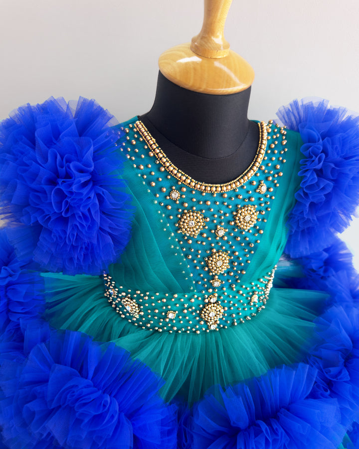 Peacock and royal blue birthday dress for girls with heavy handwork and 3-step ruffles, ideal for parties and special occasions.