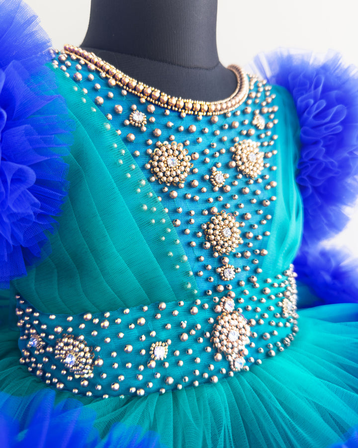 Peacock and royal blue birthday dress for girls with heavy handwork and 3-step ruffles, ideal for parties and special occasions.