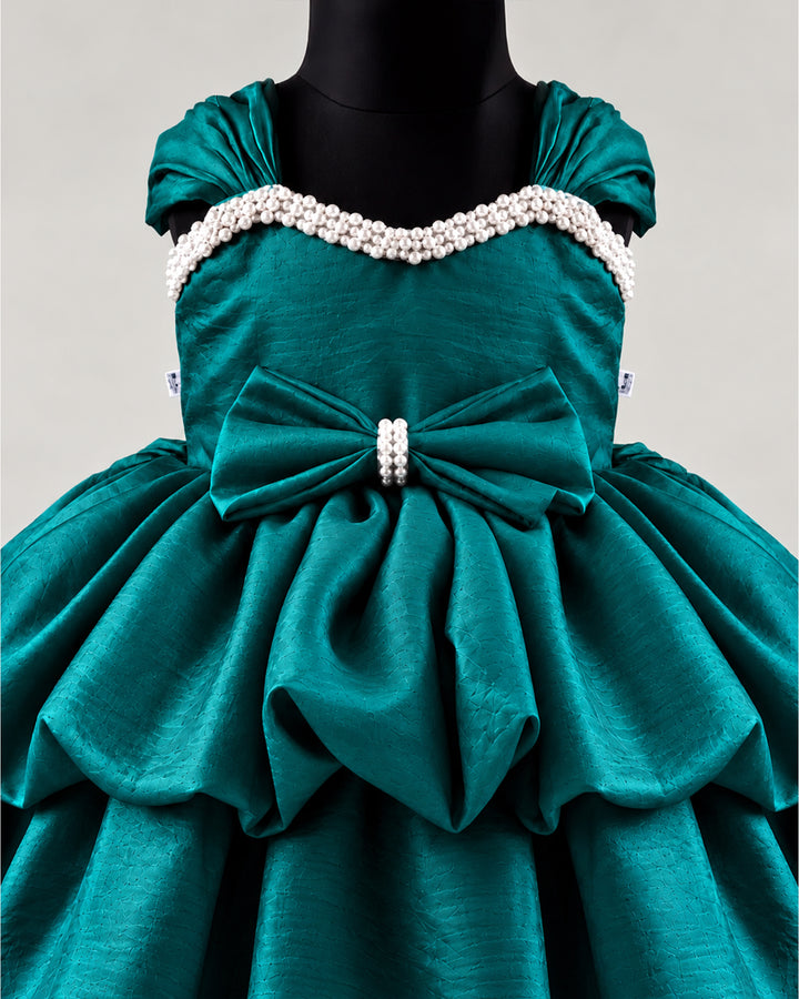 Detailed view of the peacock green silk skirt of a premium western-style party frock , Stanwells Kids.