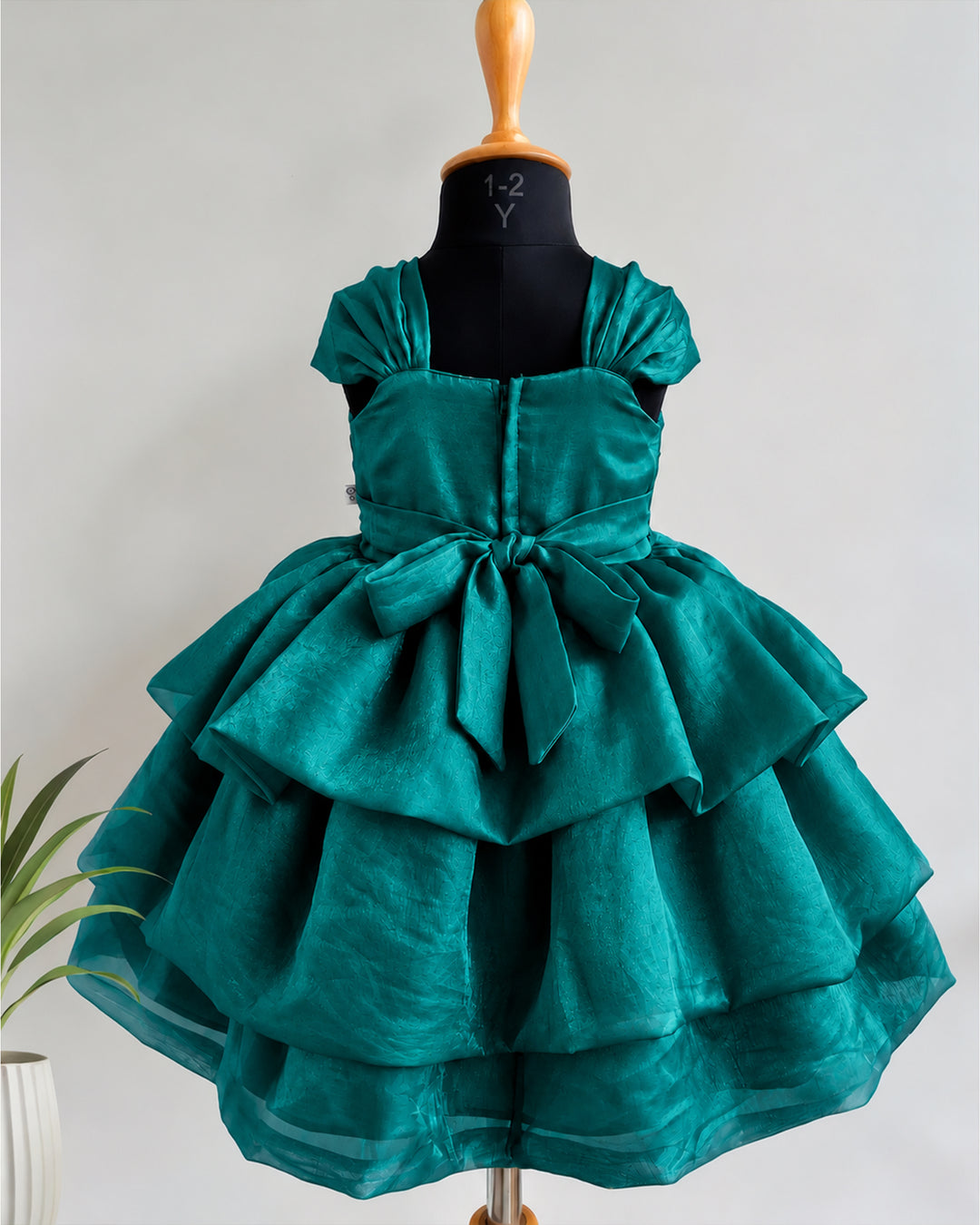 Back view of peacock green silk birthday frock for baby girl showcasing the elegant back design and premium finishing.