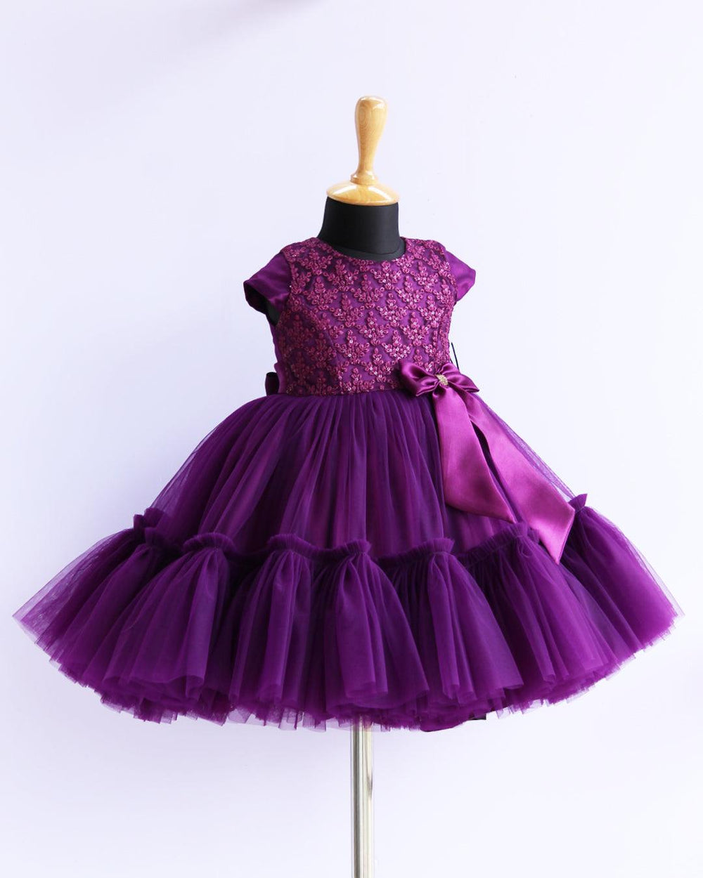 Purple Sequins Thread Embroidery Flared Ruffles Birthday Frock
Material: Purple mono nylon soft net fabric is used for the bottom of the skirt. End of the frock is designed in a pleated ruffles pattern. Yoke portion is designed