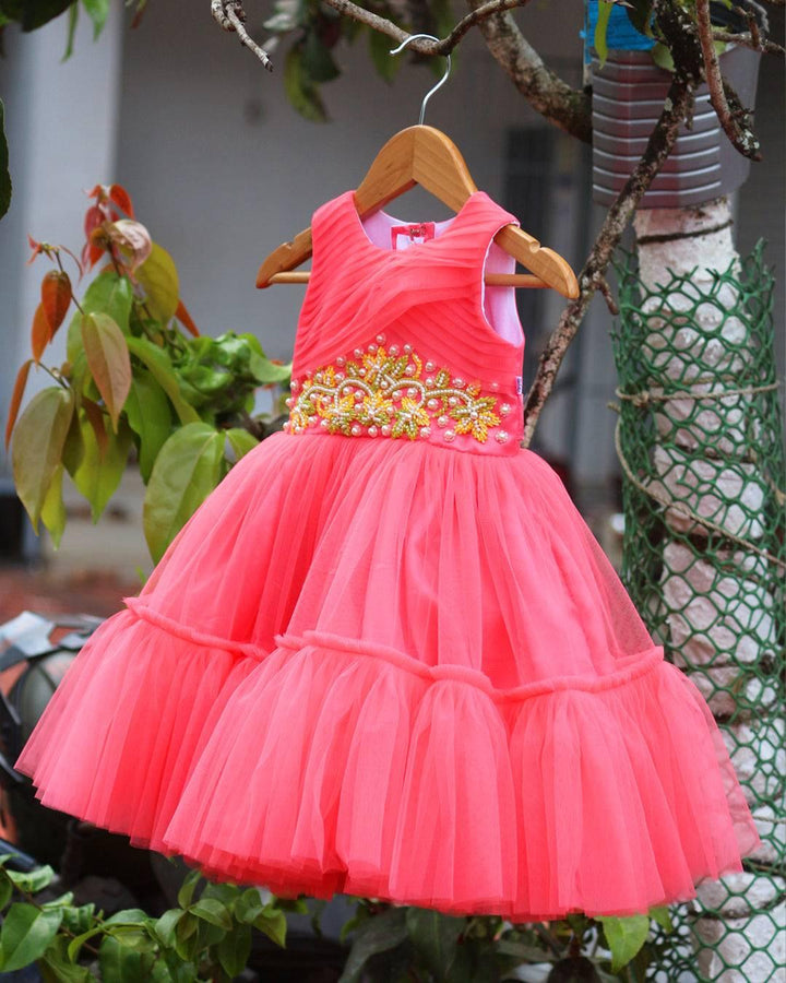 Peach Beads Handwork Birthday Frock
Material: Peach mono net with layered and ruffles on the end portion. Yoke portion is designed with pleated pattern and mukti colour beads handwork in the centre po