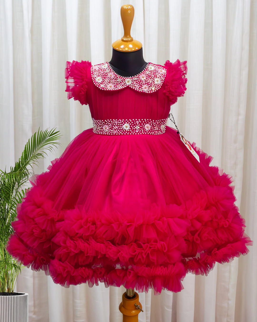 Rani pink birthday dress for baby girl with handwork

Baby girl partywear frock in rani pink shade

Peter collar pleated birthday dress for toddler girl

Rani pink baby girl frock satin lining back view

Handwork rani pink birthday dress close up detail

Baby girl first birthday partywear pink frock

Designer rani pink frock for baby girl celebration

Toddler girl birthday dress with pleated yoke