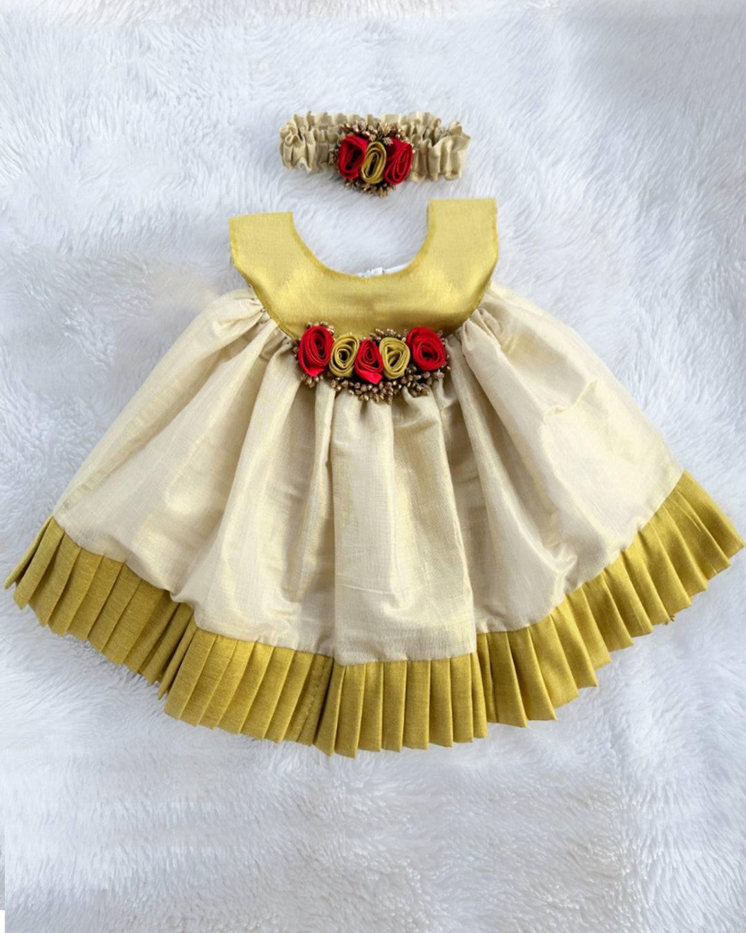 Cream & Gold Kerala Traditional Tissue frock - Matching Hairbad
Material: Cream shade kerala kasavu handloom fabric. Center portion is highlighted with red &amp; golden flowers with pollens attached. Beautifully designed outfit 