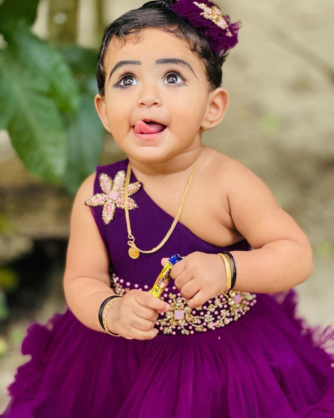 Aishu's Purple Shade Pleated Ruffled Frock
Material: Aishu's Purple Shade Pleated Ruffled Frock mono net with layered and ruffles on the end portion. Yoke portion is designed with pleated pattern and a handw