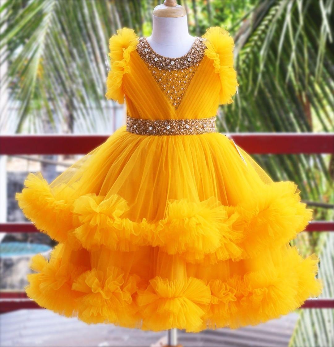 Mango Yellow Handwork Two Layer Ruffled Frock
Material: Mango Yellow  Shade Pleated Ruffled Frock mono net with layered and ruffles on the end portion. Yoke portion is designed with pleated pattern and golden b