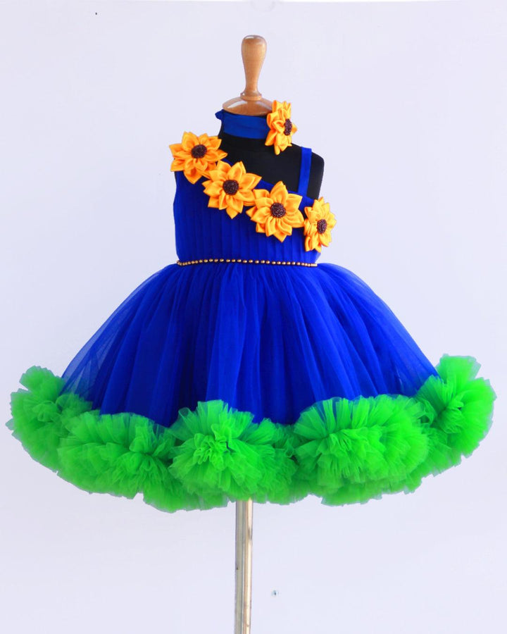 Sunflower theme royal blue and green colour  frock.
Material: Royal blue and green colour sunflower theme frock. Centre portion of the frock is hand beaded belt and the yoke portion yellow colour big satin sunflower 